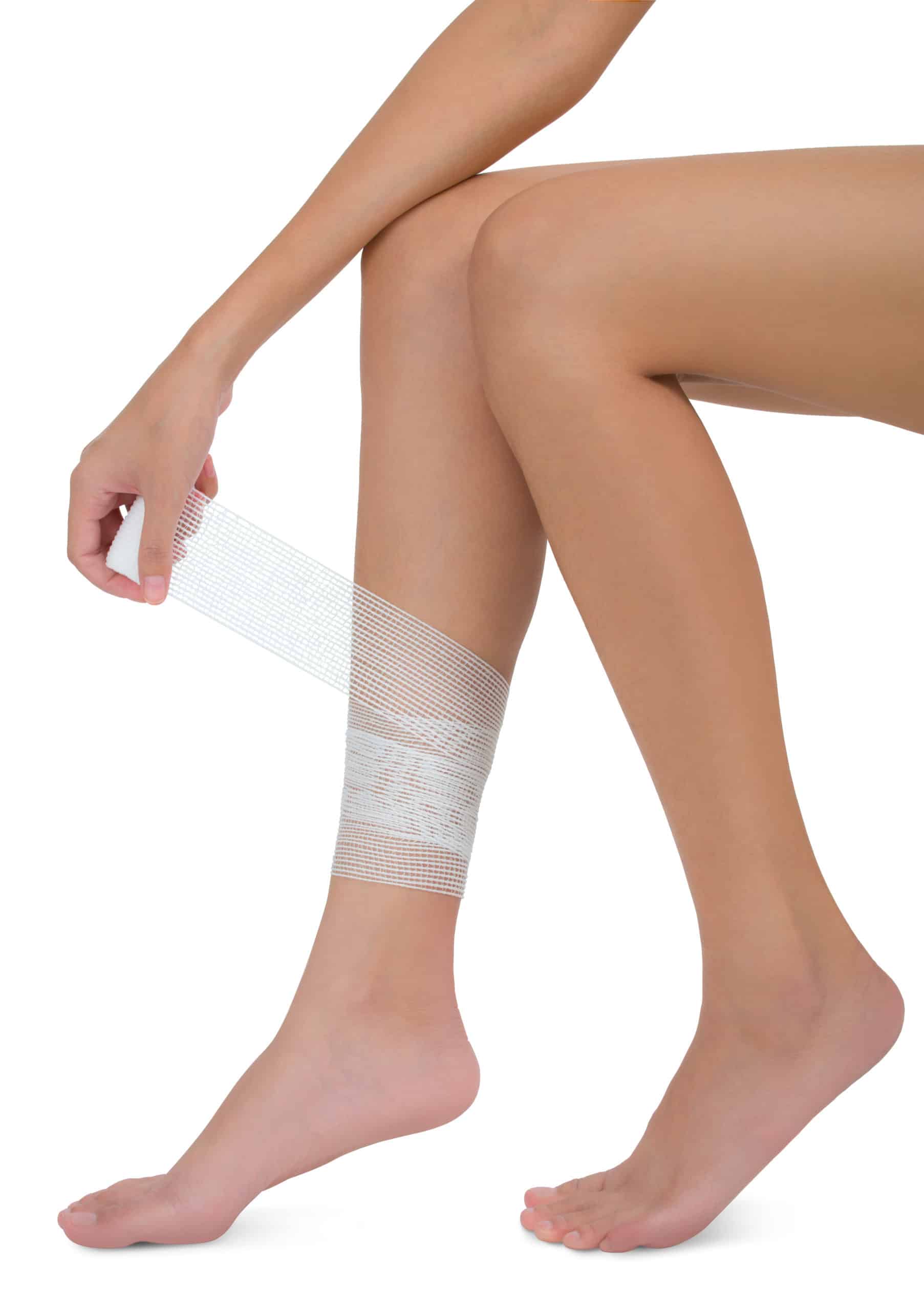 woman bandaging and first aid her beautiful Healthy long leg in pain area, Isolated on white background.